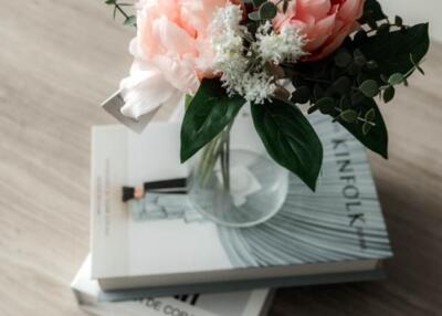 Vase with flowers on books on a table