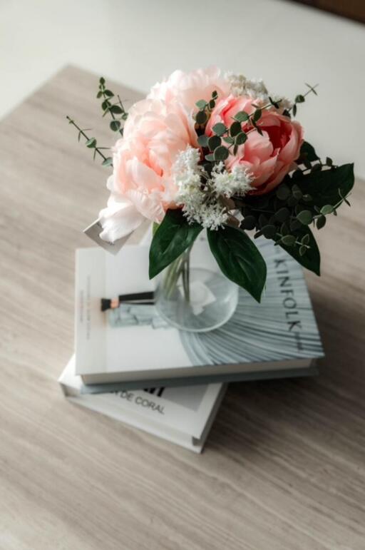 Vase with flowers on books on a table