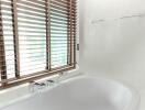 Modern bathroom with a bathtub and window blinds