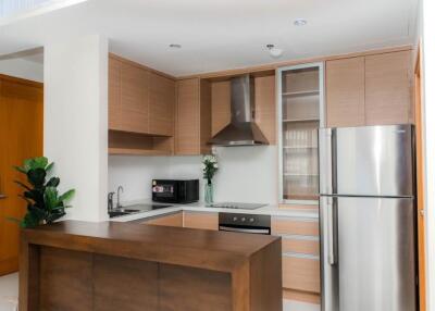 Modern kitchen with wooden cabinets, stainless steel appliances, and island