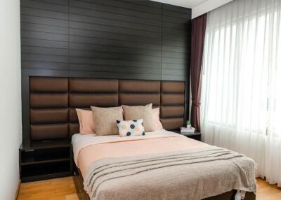 Modern bedroom with padded headboard and large windows