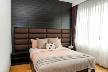 Modern bedroom with padded headboard and large windows