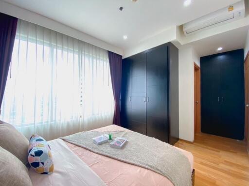 Modern bedroom with large windows and built-in wardrobe