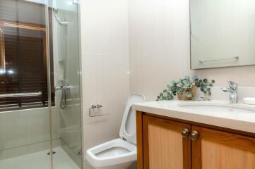 Modern bathroom with glass shower, toilet, and wooden vanity unit