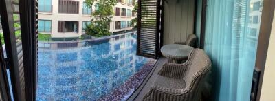 Balcony view with table and chairs overlooking a pool