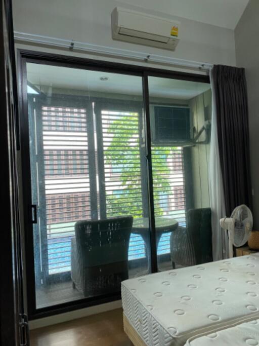 Bedroom with large glass sliding door leading to a balcony