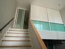 Staircase leading to a room with a glass partition