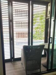 A cozy balcony with wicker furniture and louvered windows