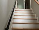 Staircase with wooden steps and glass doors at the top