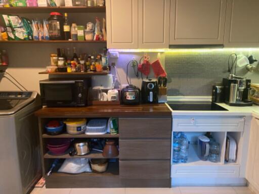 Compact kitchen with various appliances and storage shelves