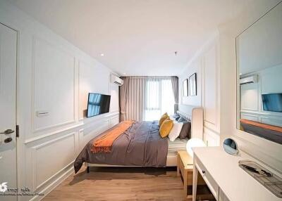 Modern bedroom with a double bed, desk, and wall-mounted TV