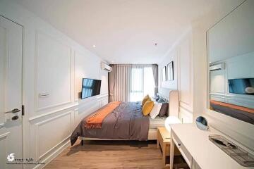 Modern bedroom with a double bed, desk, and wall-mounted TV