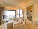 Spacious living room with chandelier and balcony view