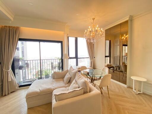 Spacious living room with chandelier and balcony view