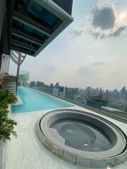 Rooftop swimming pool and jacuzzi with cityscape view