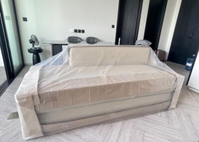 Living room with sofa wrapped in plastic