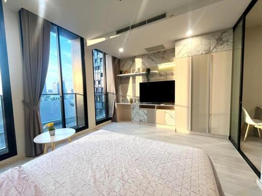 Modern bedroom with large windows and a city view