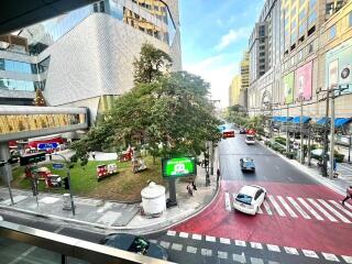 Street view from building showing surrounding area with tree, cars, and buildings