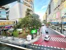 Street view from building showing surrounding area with tree, cars, and buildings