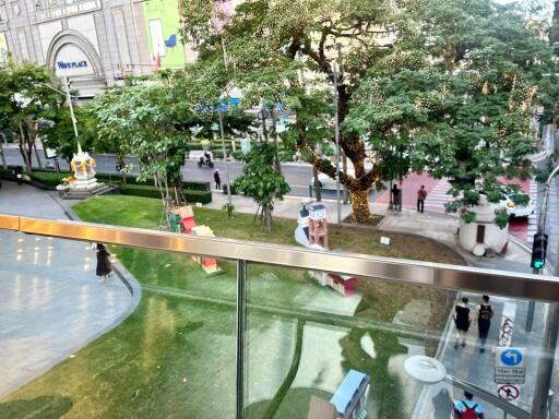 View from balcony overlooking green outdoor space and street