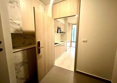 Modern kitchen entrance with wooden cabinetry and marble accents