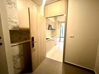 Modern kitchen entrance with wooden cabinetry and marble accents