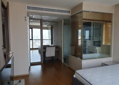 Small bedroom with attached study and glass-enclosed shower