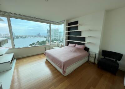 Bedroom with large window offering city and lake view