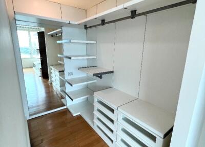 Spacious walk-in closet with built-in shelves and drawers