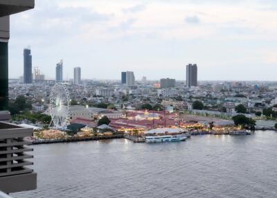 Aerial view of cityscape with waterfront, ferris wheel, and buildings