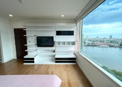 Living room with modern white entertainment center and large window with city and river view