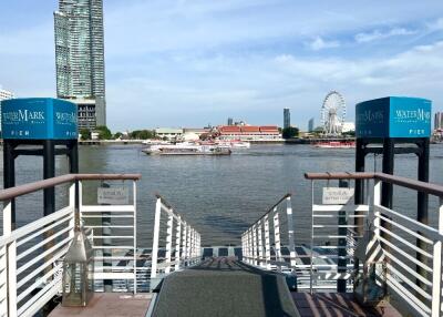 View of waterfront with pier, buildings, and ferris wheel