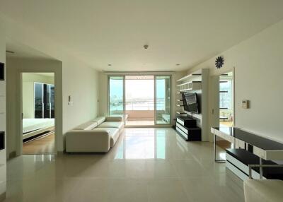 Modern living room with white sofas, TV, and balcony view