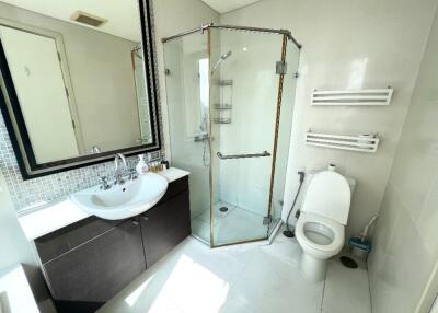 Modern bathroom with a glass shower enclosure, sink, and toilet