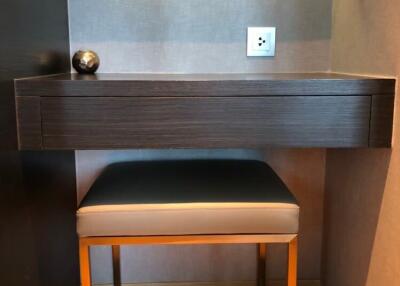 Bedroom vanity with a sleek wooden desk, stool, and mirror