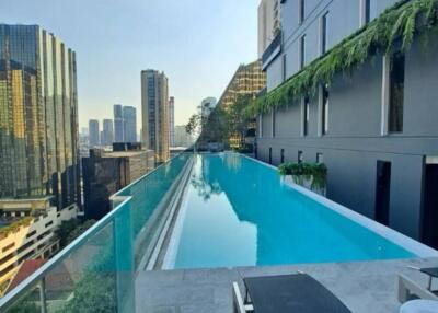 Rooftop pool area with a view of city buildings