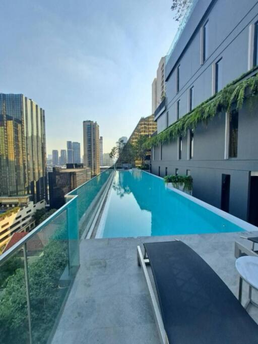 Rooftop pool area with a view of city buildings