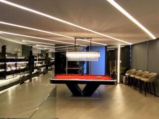 Modern recreation room with a pool table and bar seating