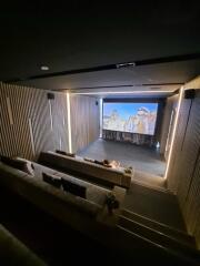 Home theater with tiered seating showing a movie on the screen