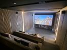 Home theater with tiered seating showing a movie on the screen