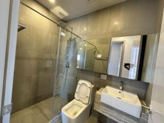 Modern bathroom with glass shower, toilet, and sink