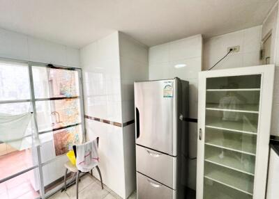 Modern kitchen with stainless steel refrigerator and glass cabinet