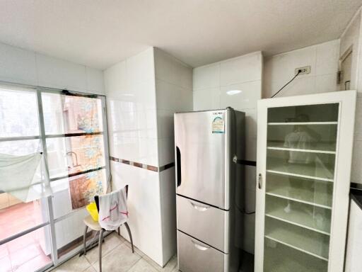 Modern kitchen with stainless steel refrigerator and glass cabinet