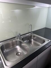 Modern kitchen sink with glass backsplash