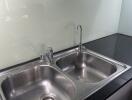 Modern kitchen sink with glass backsplash