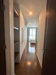 Hallway Leading to Bedroom with Shelving and Bed