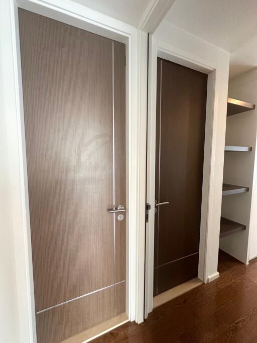 Hallway with two closed doors and shelves