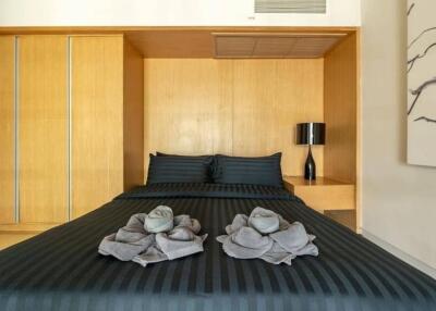 Modern bedroom with black bed linens and wooden accents