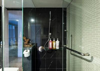 Modern bathroom with glass shower and black tiles