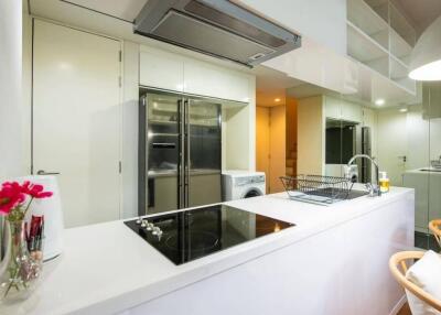 Modern kitchen with white cabinetry and stainless steel appliances.